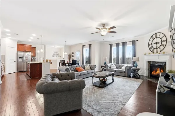 a living room with furniture fireplace and kitchen view