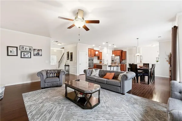 a living room with furniture kitchen view and a chandelier
