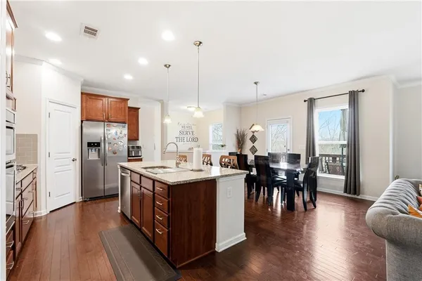 a kitchen with stainless steel appliances granite countertop a stove and a wooden floors