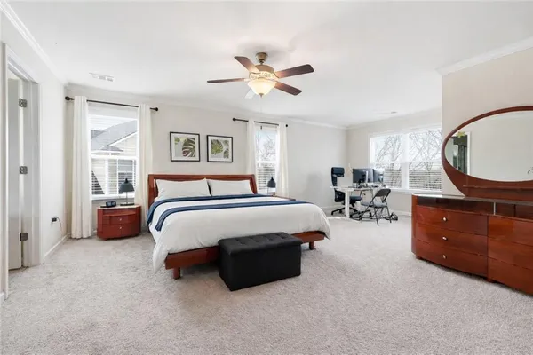 a spacious bedroom with a bed a couch and a chandelier