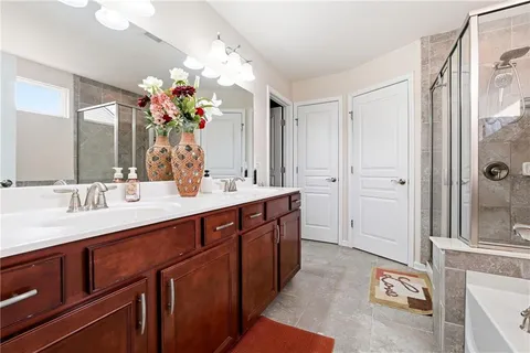 a spacious bathroom with double vanity sinks a vanity and a shower