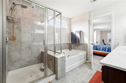 a spacious bathroom with a tub sink and mirror