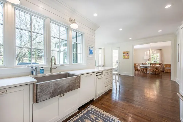 a large white kitchen with lots of counter top space and living room