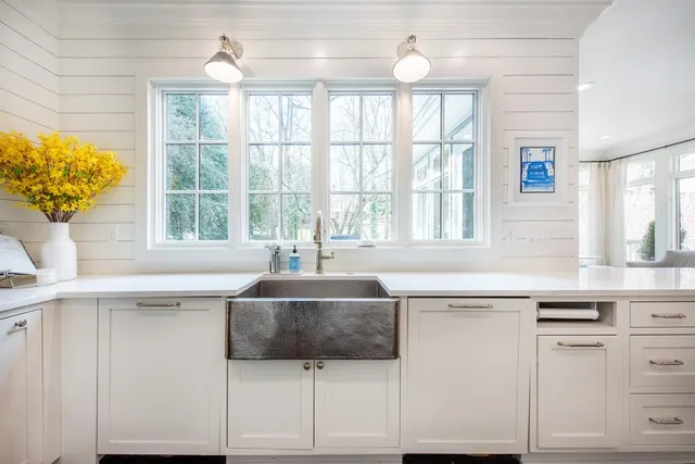 a kitchen with stainless steel appliances a sink and a large window