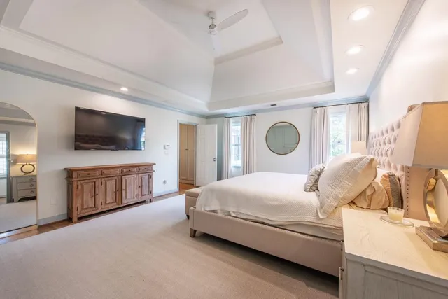 a bedroom with a bed and flat tv screen on the dresser