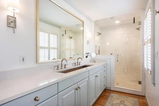 a bathroom with double vanity and a mirror