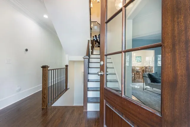 a view of a hallway with wooden floor and door
