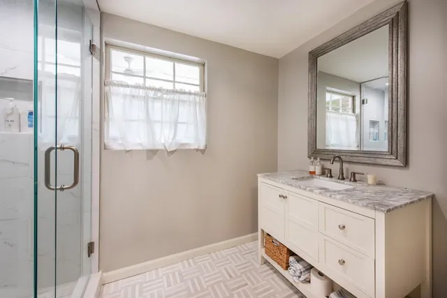 a bathroom with a granite countertop sink and a mirror