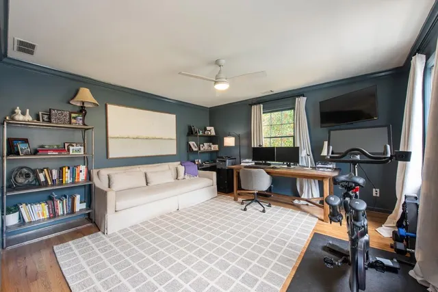 a living room with furniture a flat screen tv and a book shelf