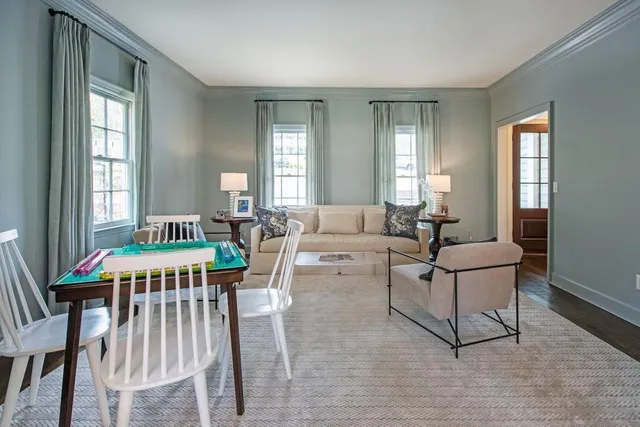 a living room with furniture a dining table and a window