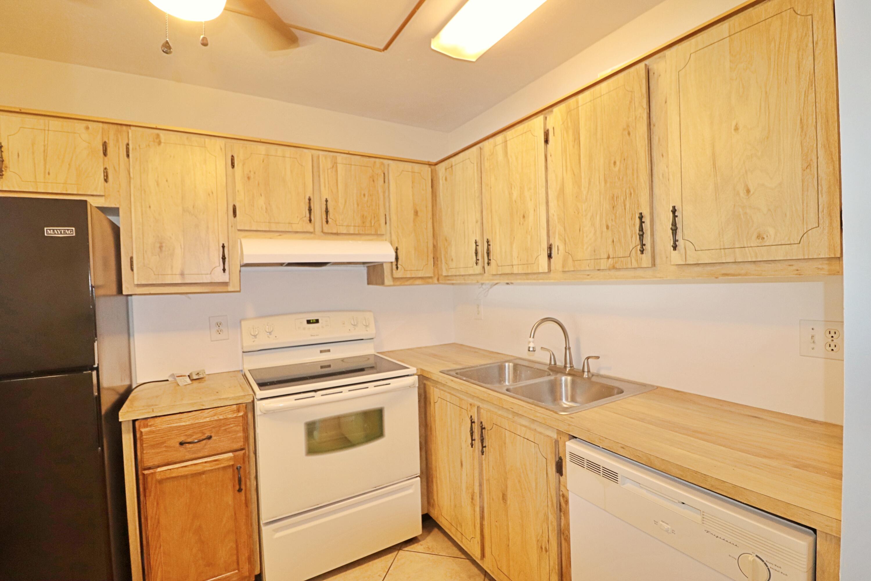 831 Timberview Drive, Unit C Fort Pierce, FL 34982 - Photo 8 of 18 a kitchen with stainless steel appliances white cabinets and a refrigerator