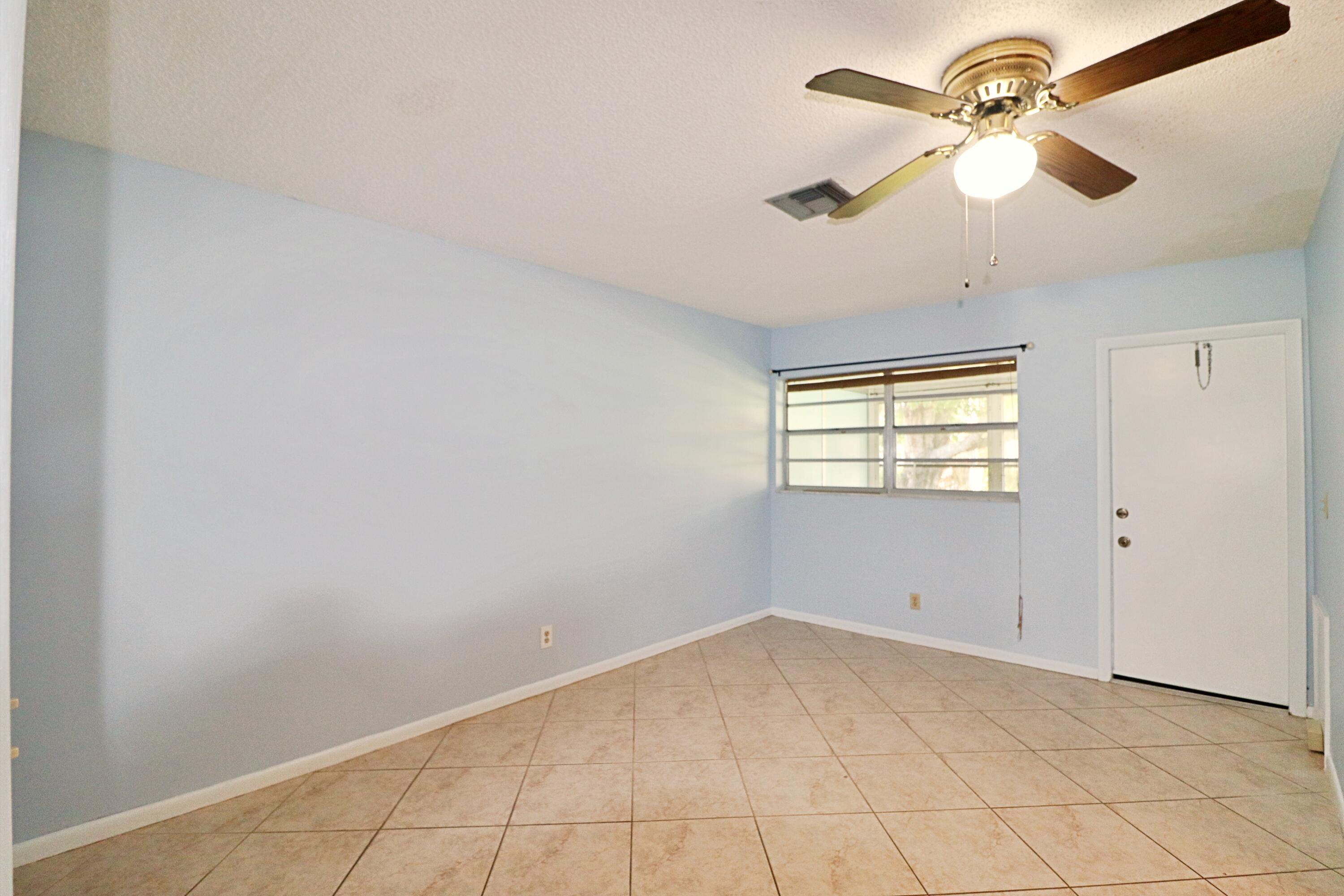 831 Timberview Drive, Unit C Fort Pierce, FL 34982 - Photo 10 of 18 wooden floor in an empty room with a window