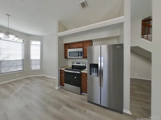 a kitchen with stainless steel appliances granite countertop a refrigerator and a sink