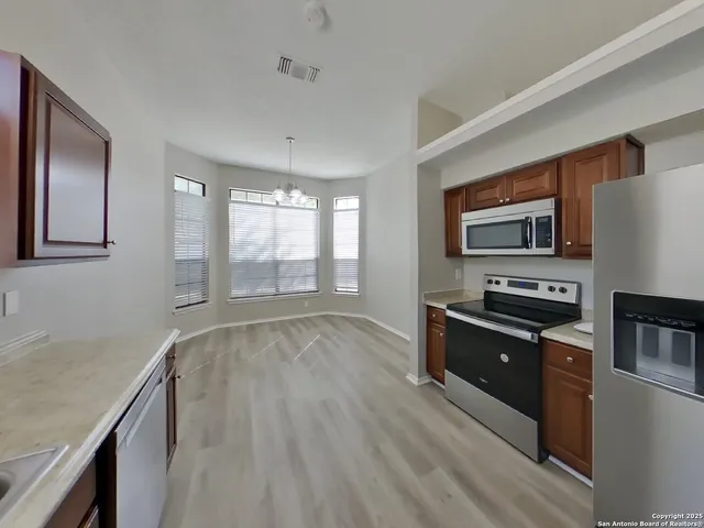 a kitchen with granite countertop a refrigerator stove and sink
