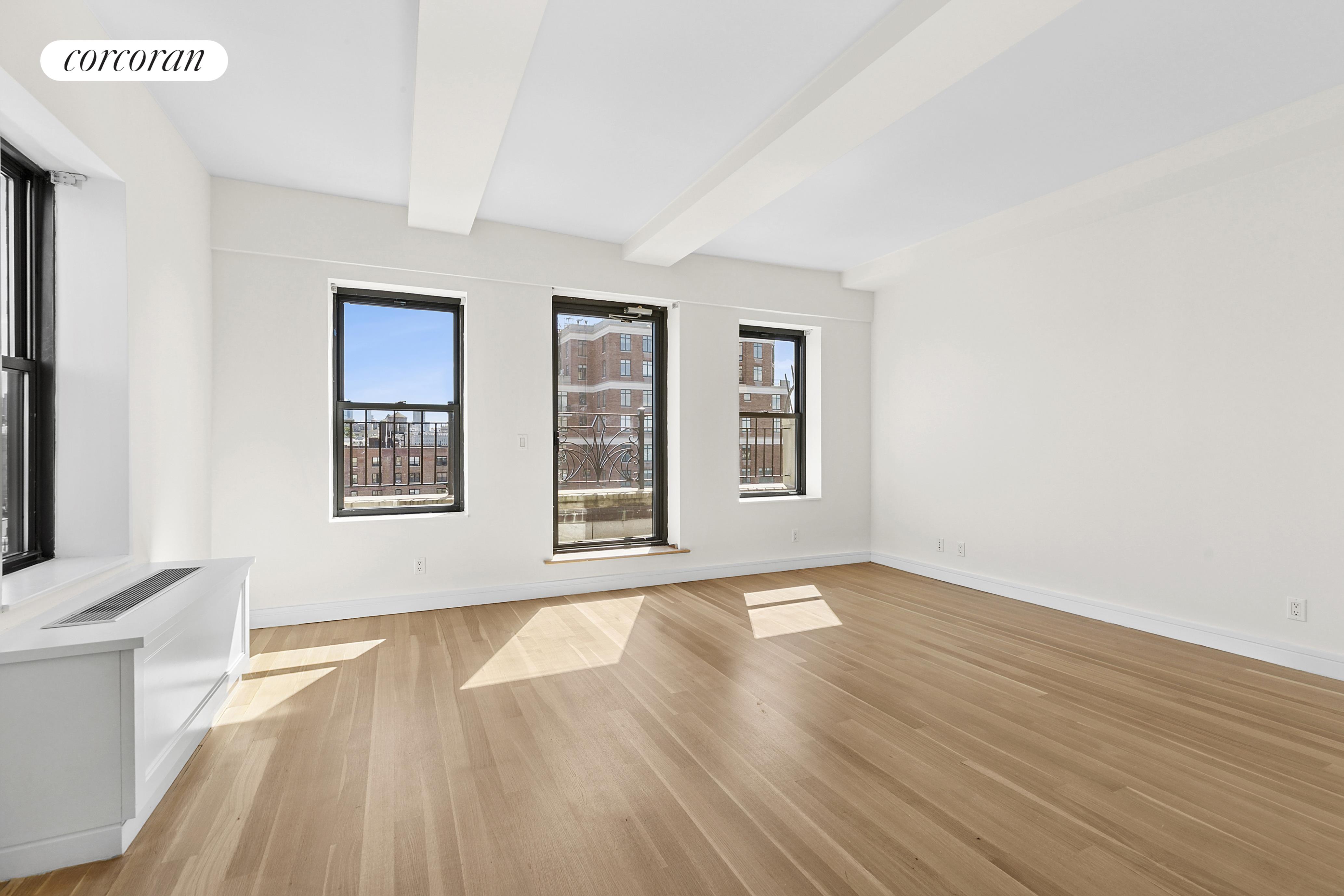 230 Riverside Drive, Unit 19L Manhattan, NY 10025 - Photo 11 of 18 an empty room with wooden floor and windows