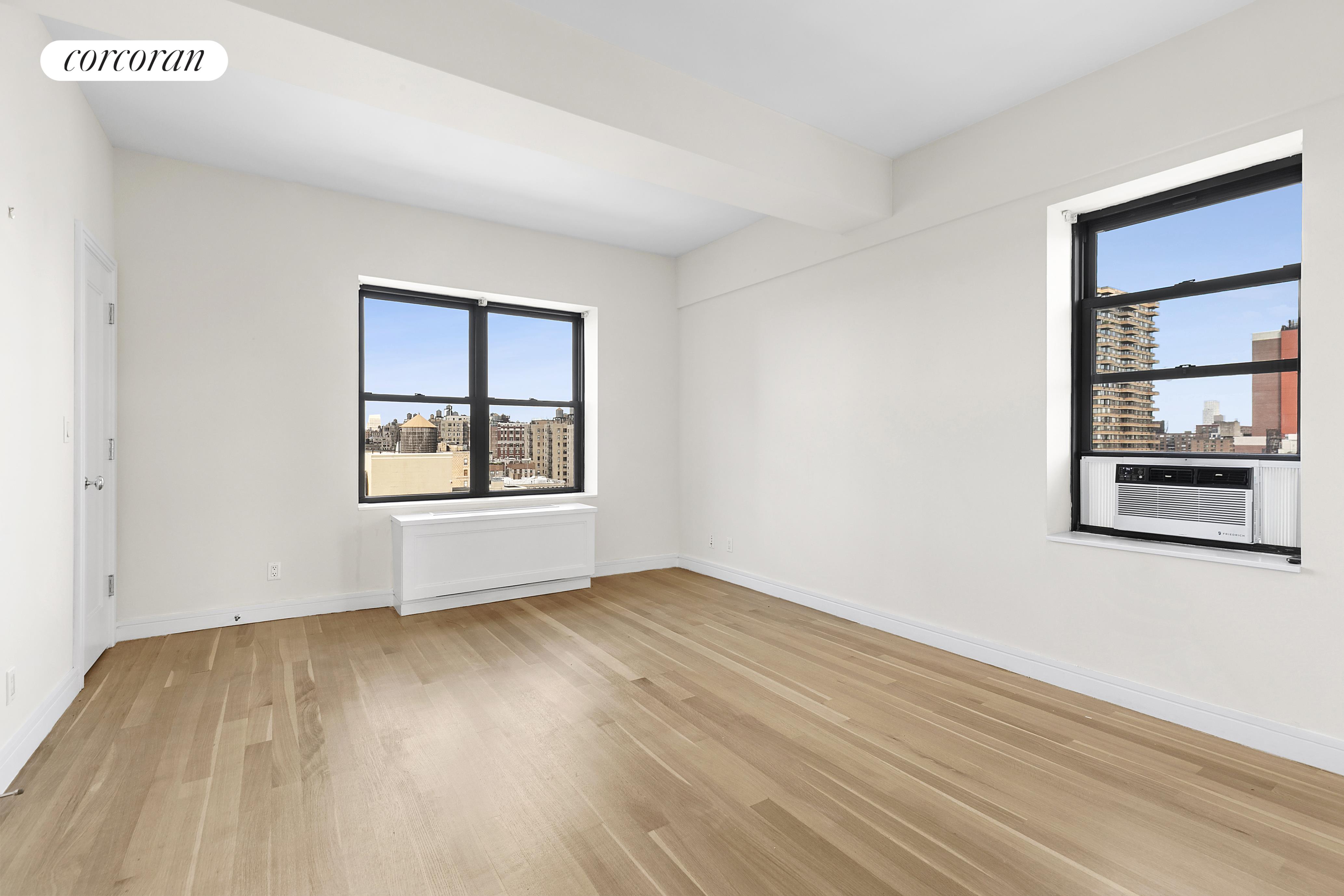 230 Riverside Drive, Unit 19L Manhattan, NY 10025 - Photo 14 of 18 an empty room with wooden floor and windows