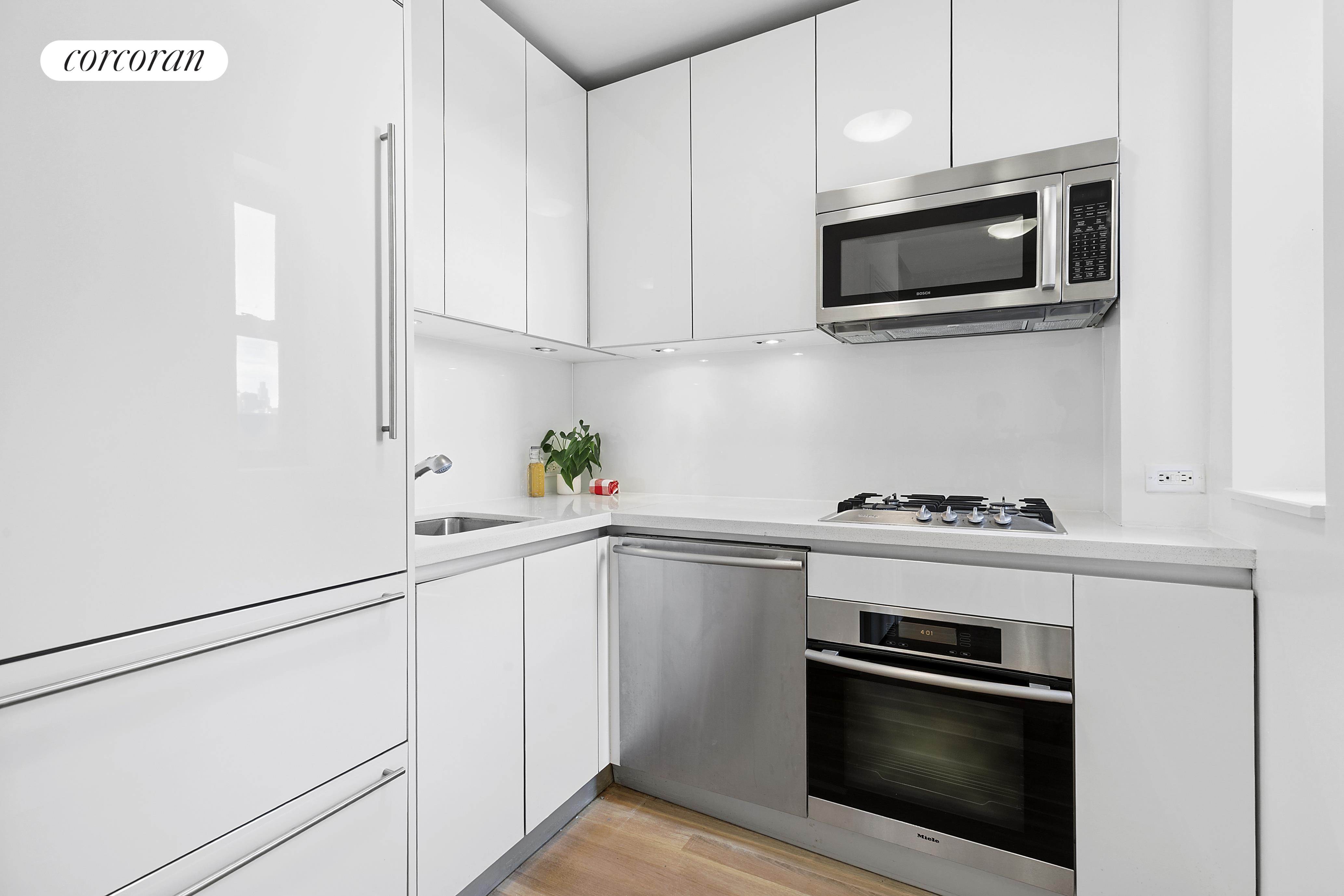 230 Riverside Drive, Unit 19L Manhattan, NY 10025 - Photo 6 of 18 a kitchen with stainless steel appliances white cabinets and a stove top oven