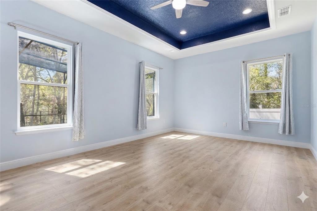 493 Nowell Loop DeLand, FL 32724 - Photo 15 of 33 a view of an empty room with a window and wooden floor