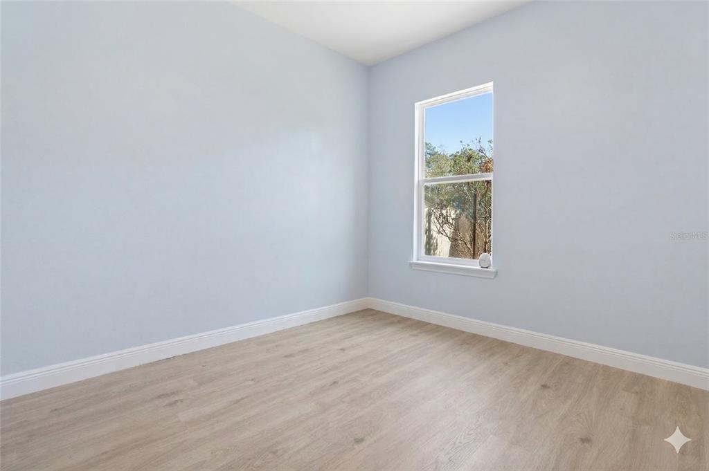 493 Nowell Loop DeLand, FL 32724 - Photo 21 of 33 an empty room with wooden floor and windows