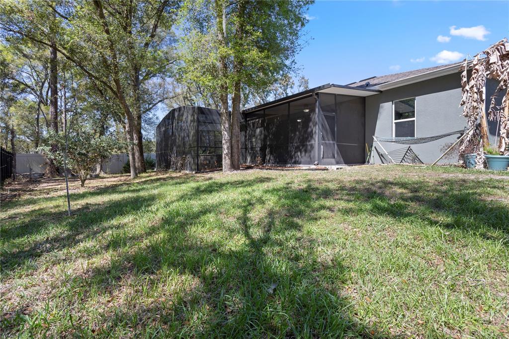 493 Nowell Loop DeLand, FL 32724 - Photo 30 of 33 a backyard of a house with large trees and wooden fence