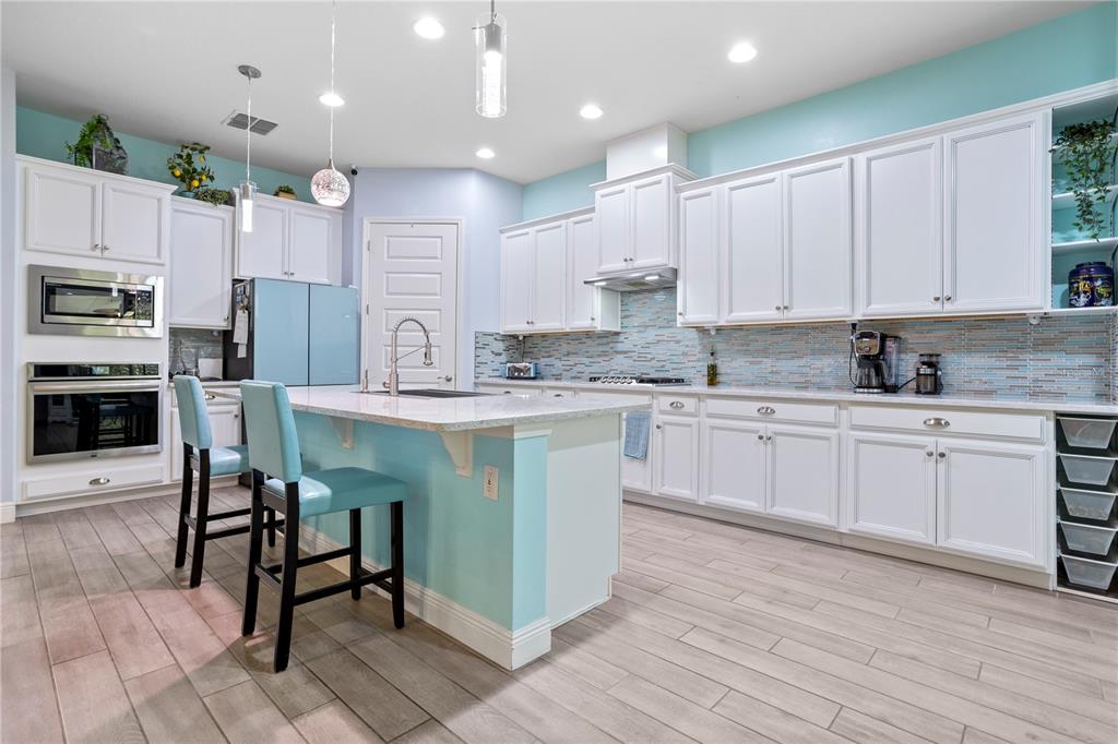 493 Nowell Loop DeLand, FL 32724 - Photo 4 of 33 a kitchen with kitchen island granite countertop a sink a stove a microwave and cabinets