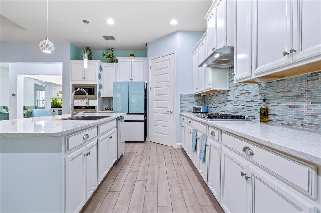 493 Nowell Loop DeLand, FL 32724 - Photo 5 of 33 a large kitchen with stainless steel appliances kitchen island granite countertop a stove a sink and a refrigerator