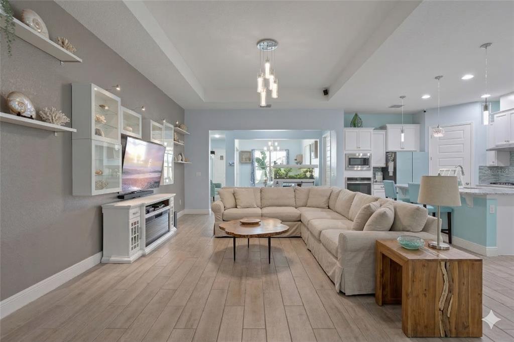 493 Nowell Loop DeLand, FL 32724 - Photo 8 of 33 a living room with kitchen island furniture and a wooden floor