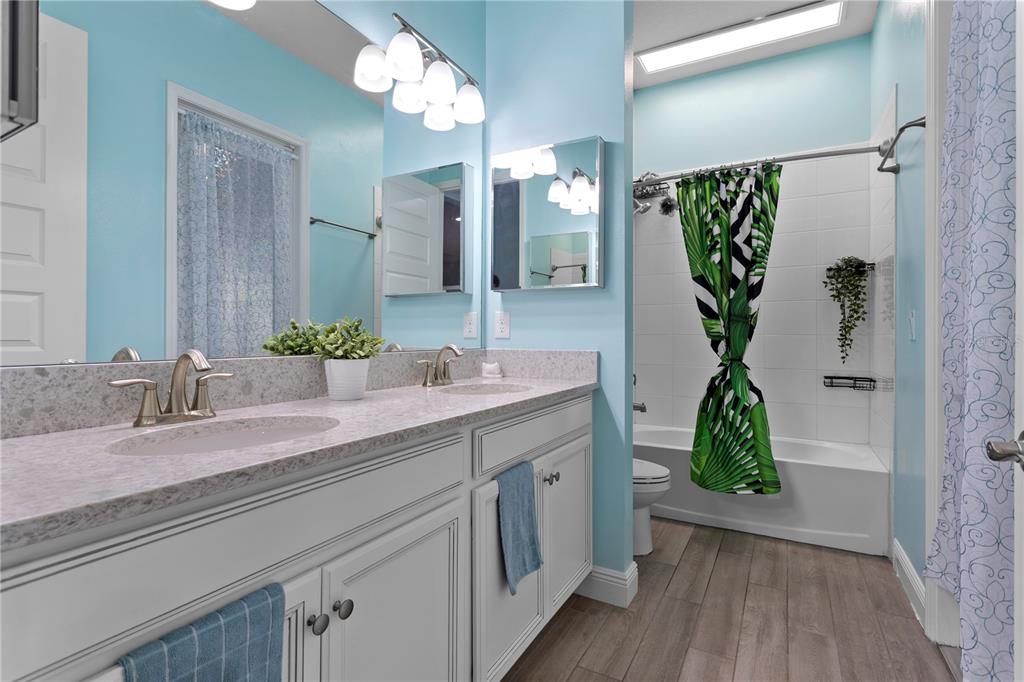 493 Nowell Loop DeLand, FL 32724 - Photo 9 of 33 a bathroom with a granite countertop shower sink and mirror