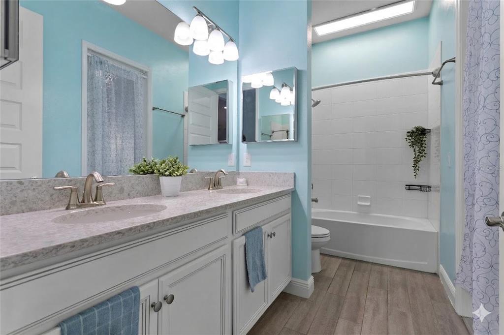 493 Nowell Loop DeLand, FL 32724 - Photo 10 of 33 a bathroom with a bathtub double sink and a mirror
