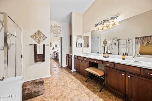 a spacious bathroom with a sink a large mirror and a shower