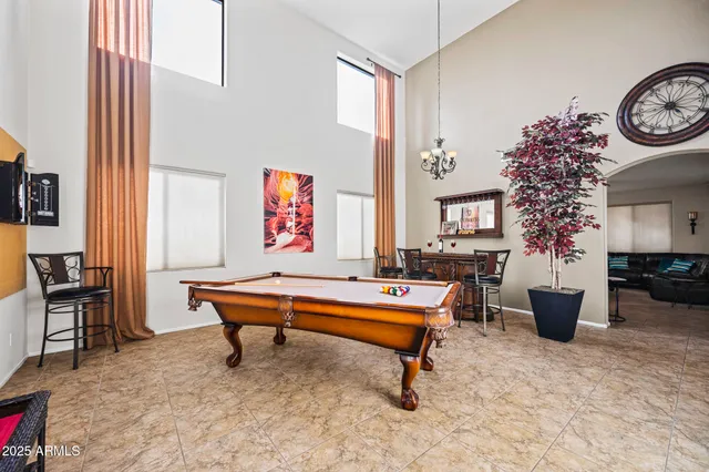 a room with furniture pool table and paintings on the wall