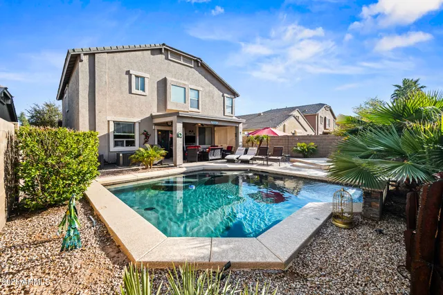 a view of a house with swimming pool and sitting area