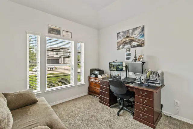 a view of a workspace with lounge chair and a window
