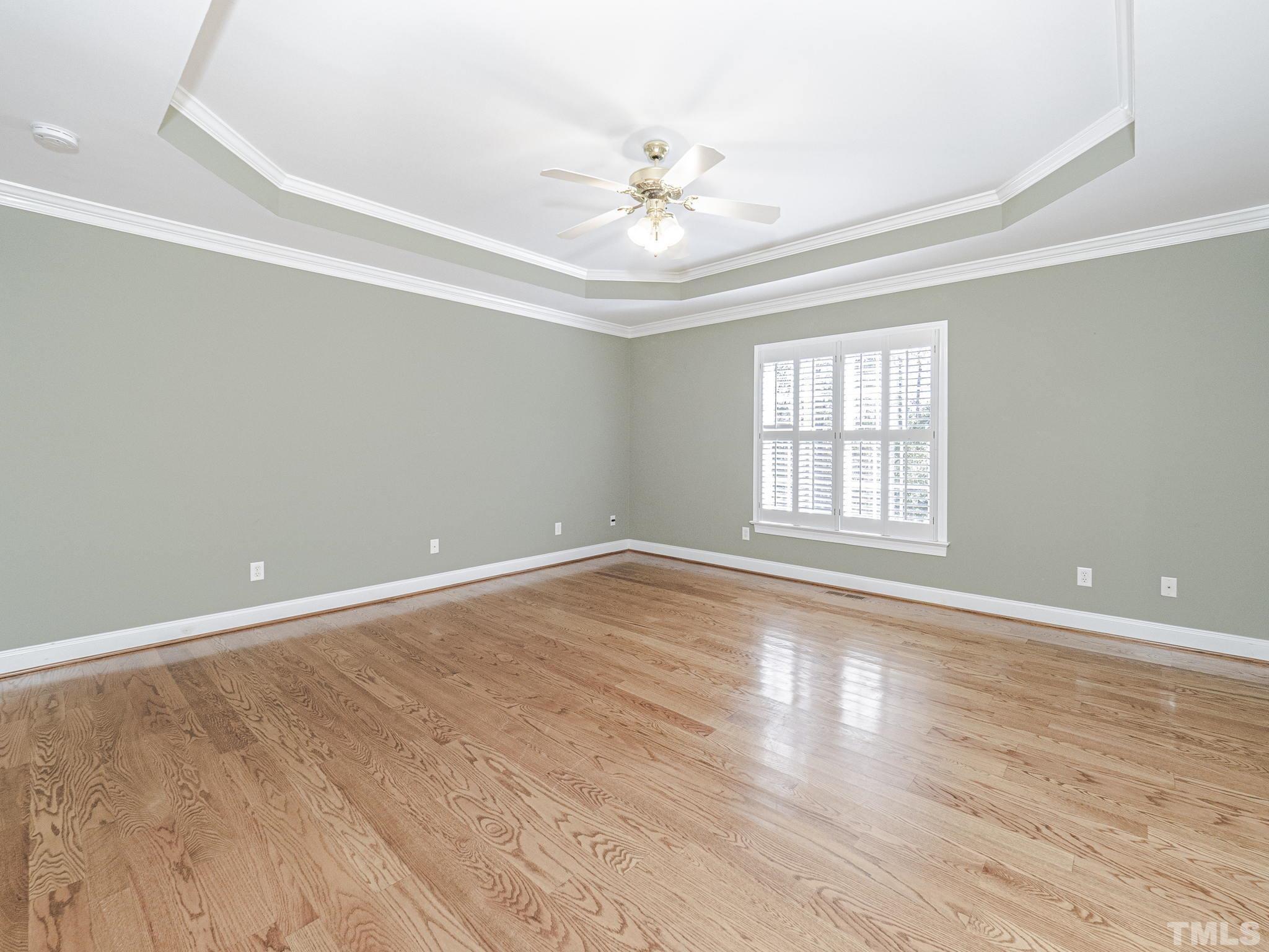 726 Pope Lake Road Angier, NC 27501 - Photo 16 of 29 an empty room with wooden floor chandelier fan and windows