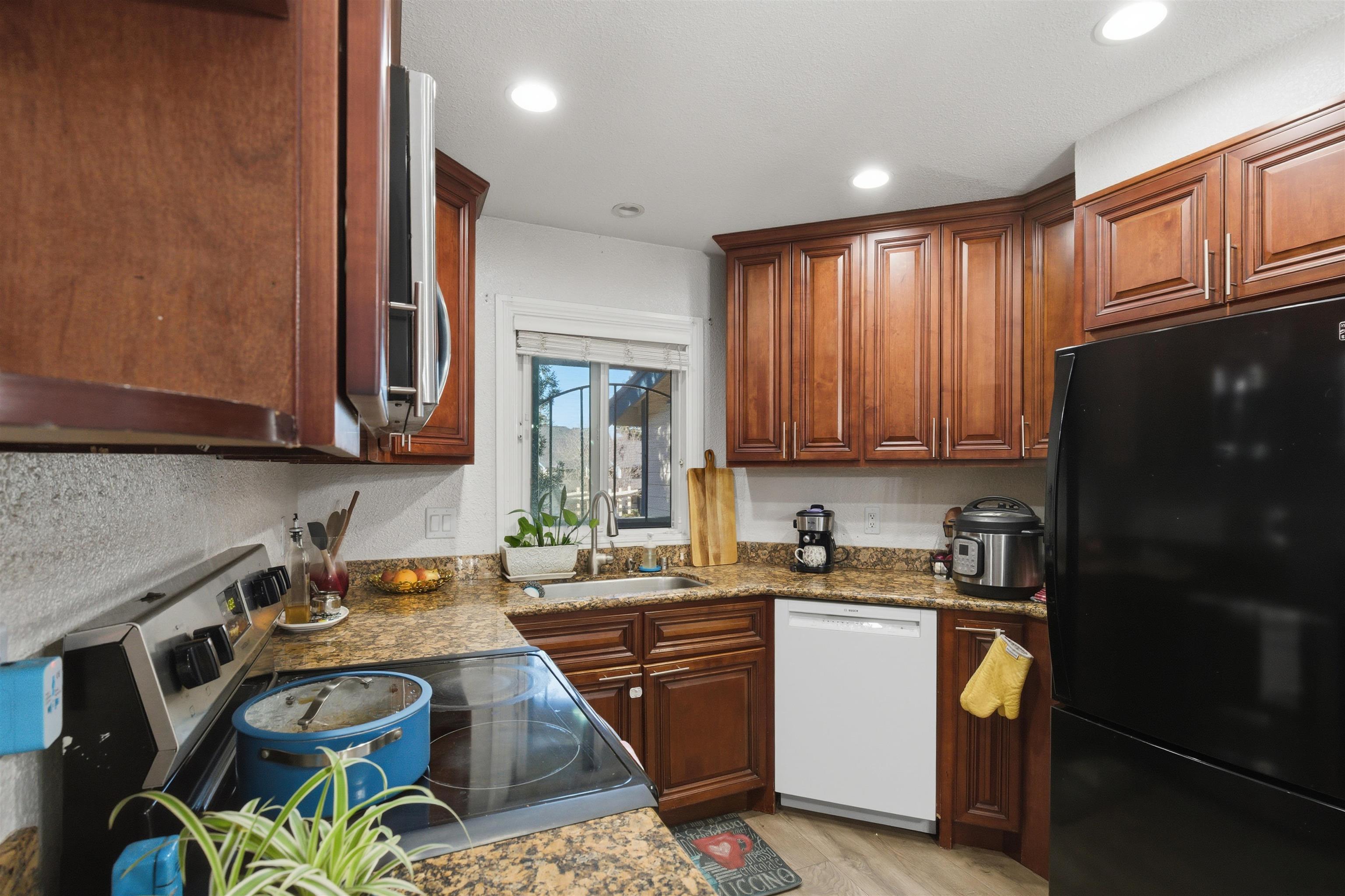 370 Sequim Common Fremont, CA 94539 - Photo 23 of 28 a kitchen with a sink a stove cabinets and a refrigerator