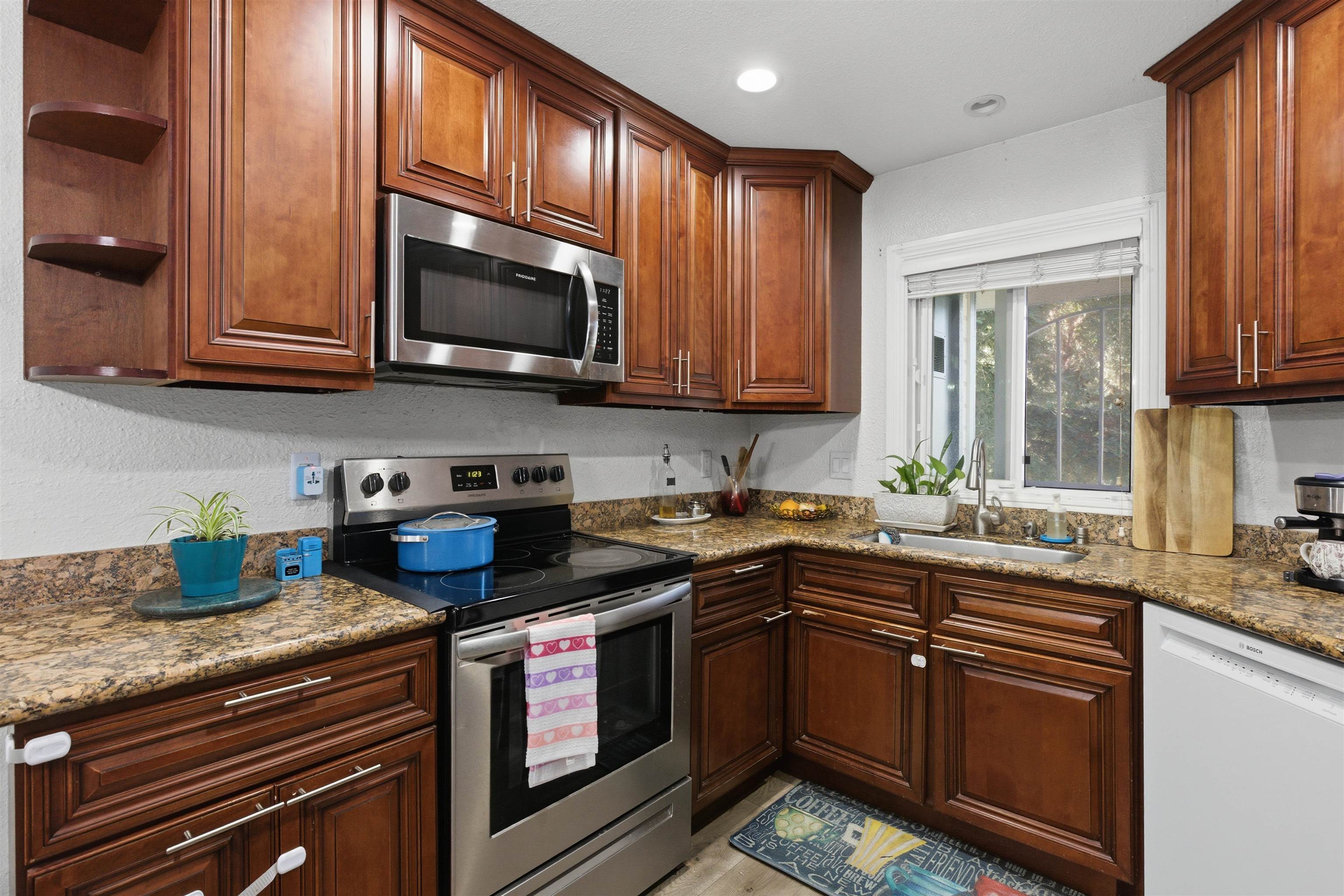 370 Sequim Common Fremont, CA 94539 - Photo 25 of 28 a kitchen with stainless steel appliances granite countertop a stove sink microwave and cabinets
