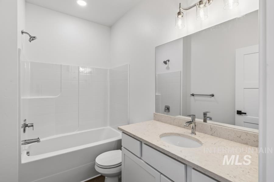 1298 Edington Moscow, ID 83843 - Photo 12 of 32 White vanity with a neutral-toned countertop, undermount sink, and chrome faucet