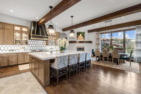 a dining hall with stainless steel appliances granite countertop a sink and dining table with wooden floor