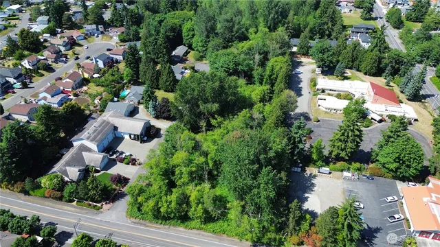 an aerial view of residential house with outdoor space and trees all around