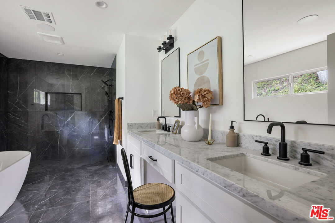17140 Rancho Street Encino, CA 91316 - Photo 17 of 28 a bathroom with a granite countertop sink a toilet a mirror and shower