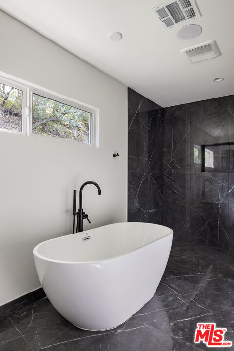 17140 Rancho Street Encino, CA 91316 - Photo 18 of 28 a white bath tub sitting in a bathroom