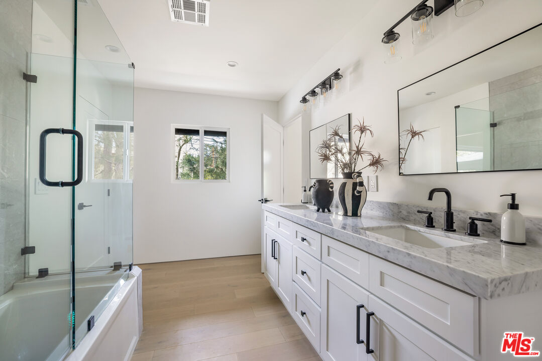 17140 Rancho Street Encino, CA 91316 - Photo 20 of 28 a bathroom with a granite countertop sink mirror and vanity