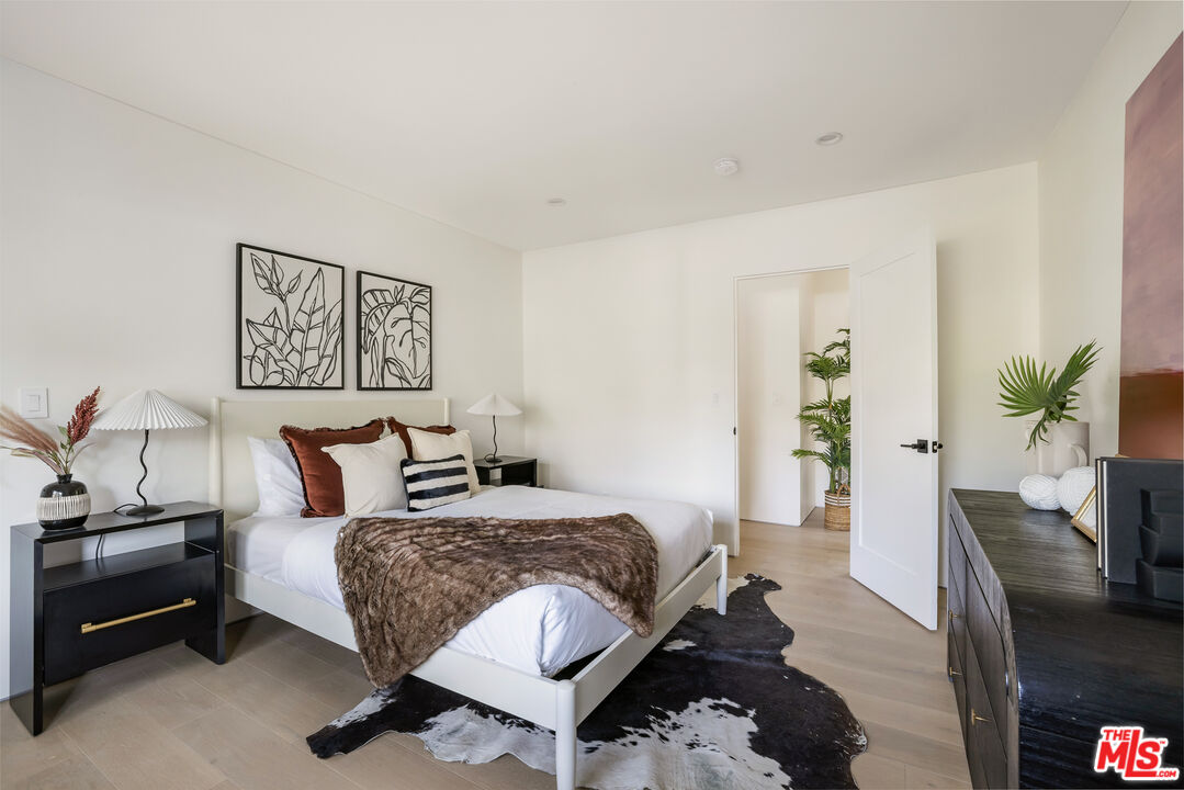 17140 Rancho Street Encino, CA 91316 - Photo 21 of 28 a bedroom with a bed and wooden floor