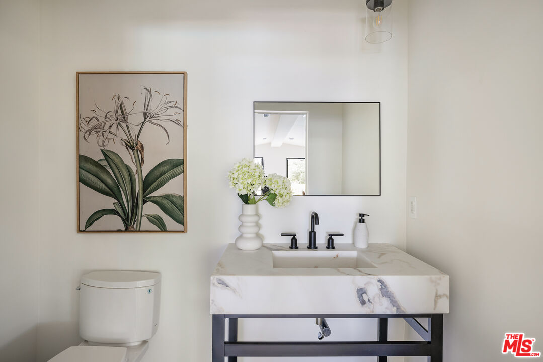 17140 Rancho Street Encino, CA 91316 - Photo 23 of 28 a bathroom with a sink a toilet and mirror