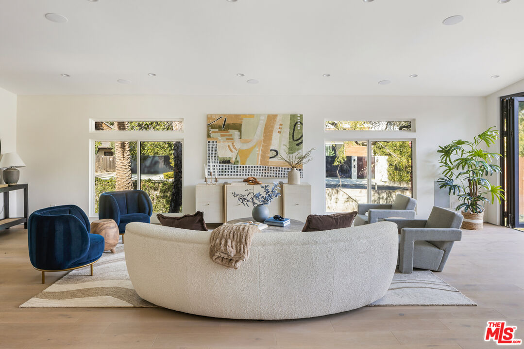 17140 Rancho Street Encino, CA 91316 - Photo 6 of 28 a living room with couches and a large mirror with wooden floor