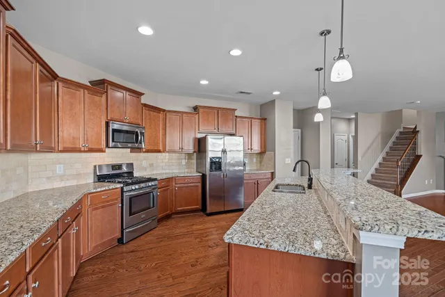 a kitchen with granite countertop stainless steel appliances and wooden cabinets