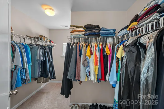 a view of walk in closet with clothes