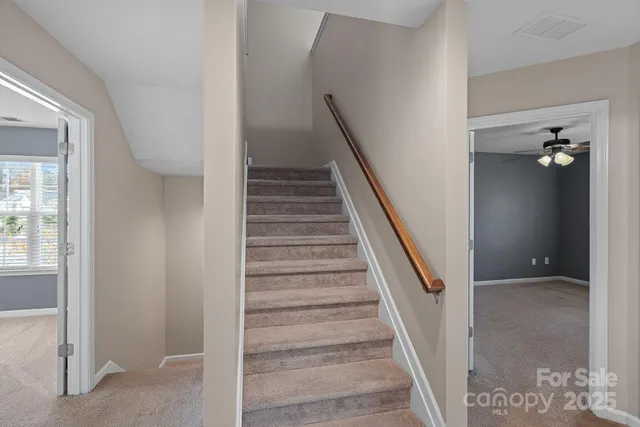 a view of an empty room with a chandelier fan