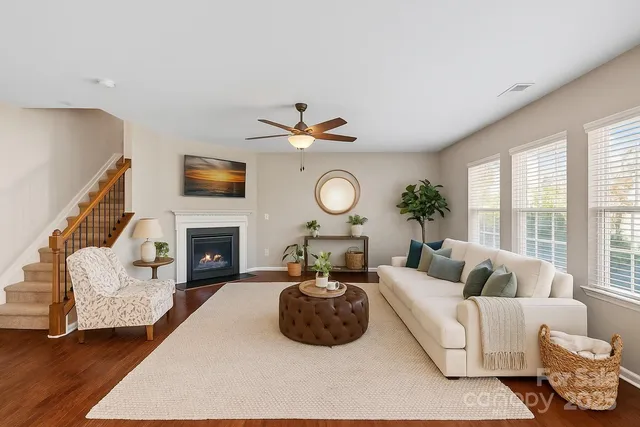 a living room with furniture a fireplace and a large window
