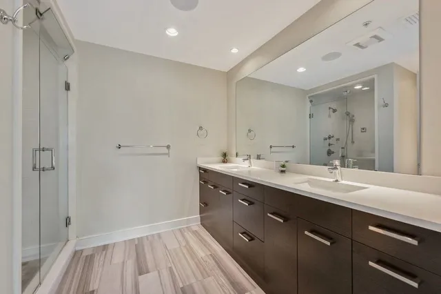 a bathroom with a sink double vanity granite tub and shower